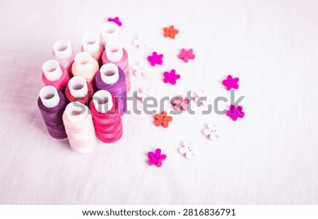 Pink thread spools scattered on white surface, sewing, threads, 