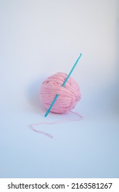 Pink threads with a ball lie on a white background.