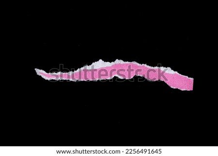 Pink torn paper piece isolated on black background