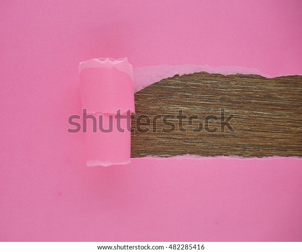 Pink torn paper with space for text. Pink torn\
paper on brown background