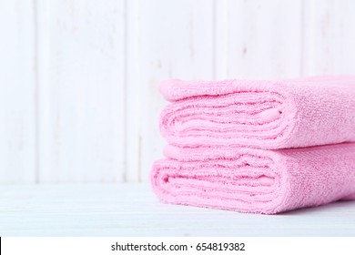 Pink towels on white wooden table