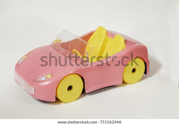 pink toy convertible for girls with yellow\
seats and wheels on white\
background