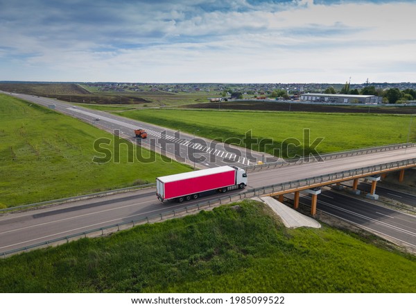 Pink Truck with\
Cargo Semi Trailer Moving on Road in Direction. Highway\
intersection junction. Aerial Top\
View
