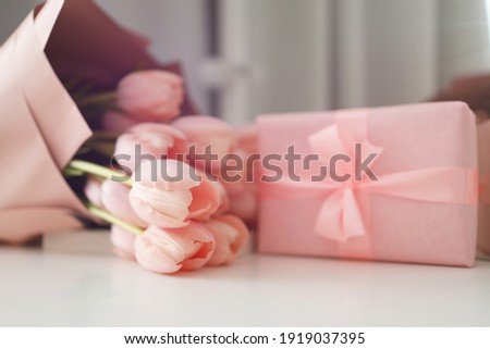 Pink tulips flowers and gift or present box pink background. Mothers Day, Birthday, Valentines Day, Womens Day, celebration concept. Space for text.