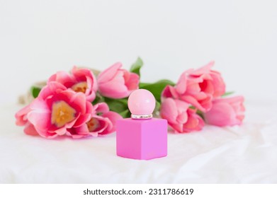 Pink tulips and perfume bottle on white background, female branding, gift for women, fresh flowers spray, promo eau product - Shutterstock ID 2311786619