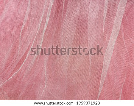 Pink tulle fabric texture top view. Coral background. Fashion rose color trendy feminine tutu skirt flat lay, female blog glossy backdrop for text sign design. Girly abstract wallpaper,textile surface