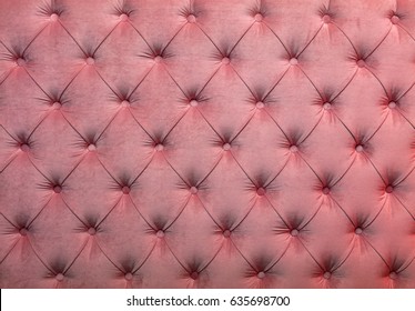 Pink velvet capitone textile background, retro Chesterfield style checkered soft tufted fabric furniture diamond pattern decoration with buttons, close up