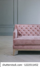 Pink Velvet Couch Against The Grey Wall