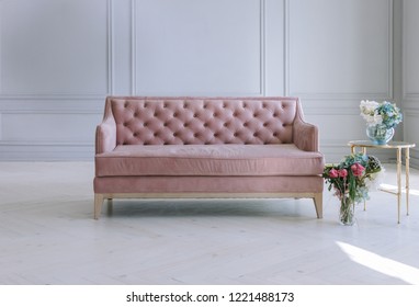 Pink Velvet Couch In The Room With Grey Walls And Flowers