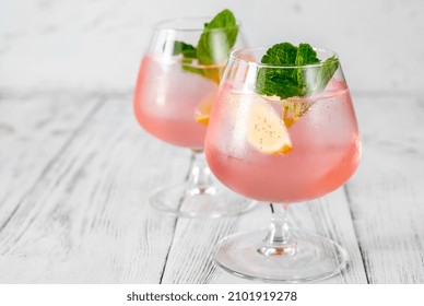 Pink Vodka Lemonade Cocktail Garnished With Lemon Wedge