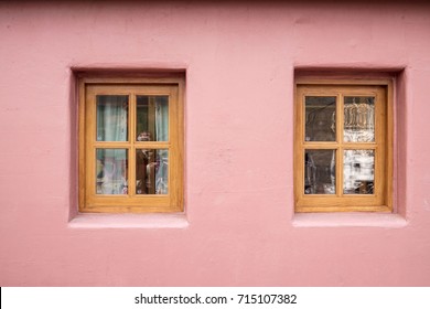 Pink wall and windows /
There are two windows on the colored wall.