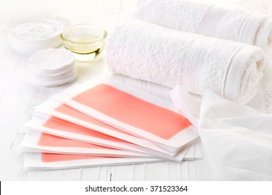 Pink Waxing Strips, Cream And Body Oil On White Wooden Background