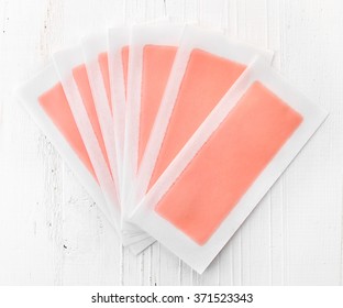 Pink Waxing Strips On White Wooden Background, Top View