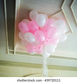 Pink And White Balloons Floating In The Room