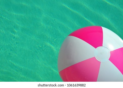 Pink And White Beach Ball In Swimming Pool. Room For Your Text.