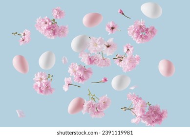 Pink and white Easter eggs adorned with cherry blossom branches, levitating against a blue background. Easter themed Springtime nature decoration concept. - Powered by Shutterstock