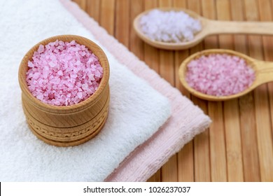 pink and white sea salt in a wooden spoon on a wooden background