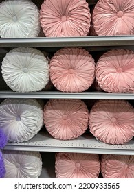 Pink And White Velvet Tufted Round Pillow On A Display Shelf At A Home Store.