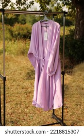 A Pink Women's Dressing Gown Hangs On A Hanger.