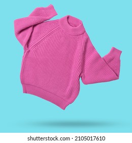 suéter de punto de lana rosa vuela como bailando, manos arriba, levita sobre el fondo de cian, concepto de compras
