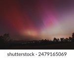 Pink, yellow and red aurora dancing over the Czech Republic. A great solar storm. Night sky under a geomagnetic storm turning pink. A miracle in the Czech Republic. Northern lights.