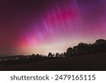 Pink, yellow and red aurora dancing over the Czech Republic. A great solar storm. Night sky under a geomagnetic storm turning pink. A miracle in the Czech Republic. Northern lights.