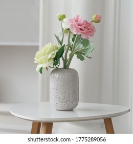 Pink and yellow roses in Modern white vase on white table