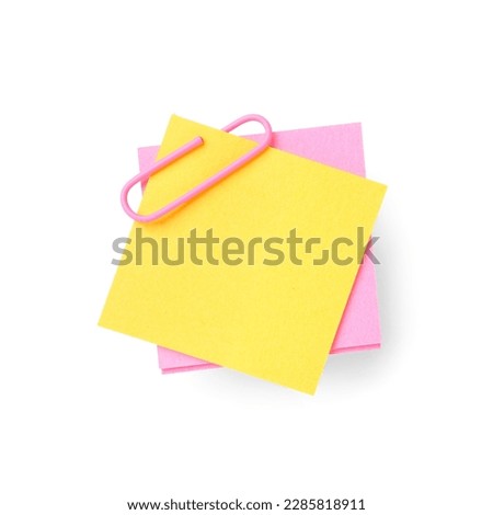 Pink and yellow sticky notes with paper clip on white background