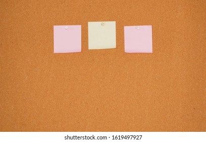 Pink And Yellow Sticky On Corkboard
