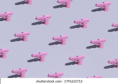 Pink-colored Pistols Pattern On A Pale Lilac Background. Pistol Toys Overload. Pink Guns On A Monochrome Lavender Background.