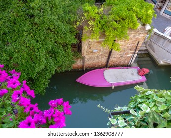 Pink/Fucsia boat moored in a Venice canal - Venezia, Italy 06/04/2019. View from the top.