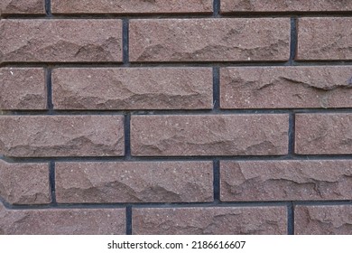 Pinkish Brown Brick Veneer Wall With Black Mortar Joints