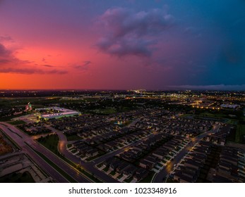 Pinks And Blues Across Sunset Sky Aerial View Above Suburb Neighborhood Real Estate Market New City Living In Suburbia Community North Of Austin , Texas During Amazing Dusk City Lights