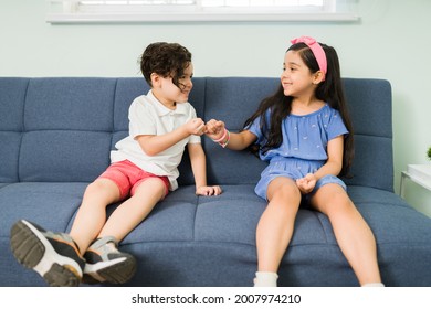 Pinky promise. Cute beautiful girl doing an oath with her little brother. Adorable siblings feeling happy while making a promise 