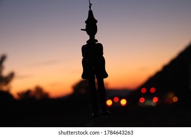 Pinocchio, Sunset, Silhouette And Car Headlights.