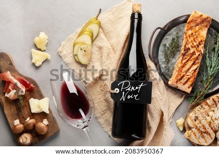 Pinot Noir on gray background. Traditional alcohol drinks. Red wine variety. Top view, flat lay, copy space