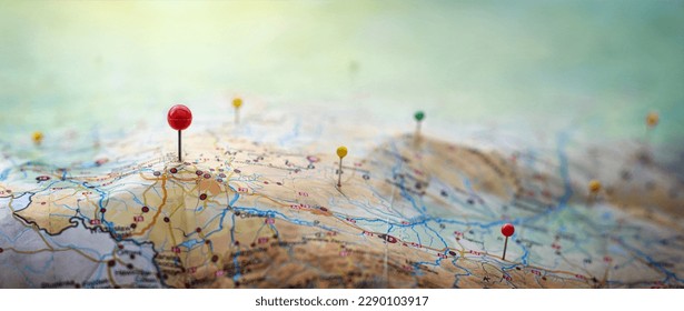 Pins on a geographic map curved like mountains. Pinning a location on a map with mountains. Adventure, discovery, navigation, geography, mountaineering, hike  and travel concept background.