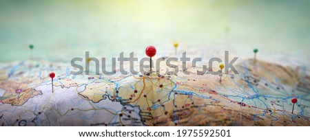 Pins on geographic map curved like mountains. Pinning  location on map with mountains. Adventure, discovery, navigation, geography, mountaineering, rock climbing, hike  and travel concept background.