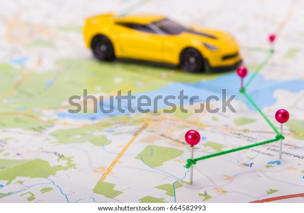 Pins on the map show the\
route. The road trip plan on the car with stop points. Copy Space\
to Paste Text
