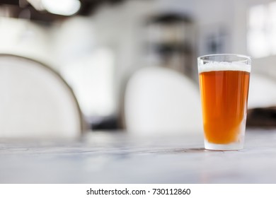 Pint of beer sitting on a grey table