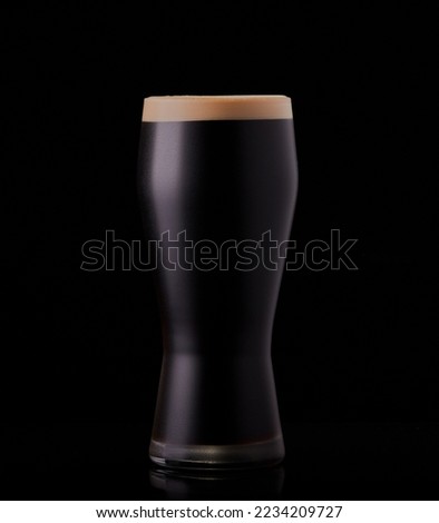 Pint of dark ale isolated on a black background.