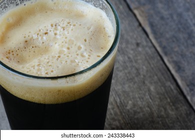 Pint Of Dark Beer On Wood Background