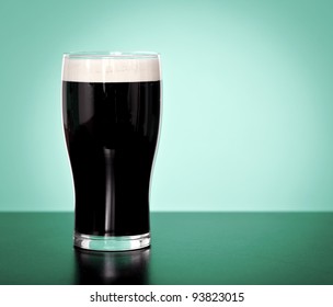 Pint Of Irish Stout Beer On A Green Background