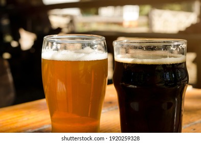 Pint Of Lager And Pint Of Stout. Craft Beer In Beer Garden With Wooden Table