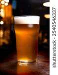 pint of pale ale craft beer on blurred pub bar background