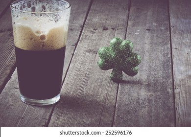 Pint Of Stout Beer With Green Shamrock With Vintage Film Filter