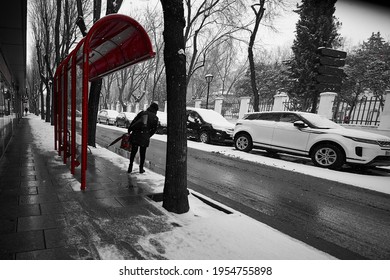 Pinto, Madrid; 01 08 2021: Person Waiting For The Bus At A Bus Shelter Overlooking The Road, Not Knowing If It Will Arrive Because Of The Snow