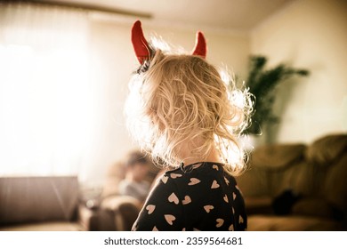 pint-sized imp with devilish horns this Halloween