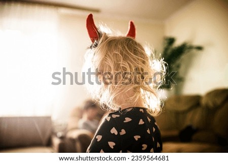 pint-sized imp with devilish horns this Halloween