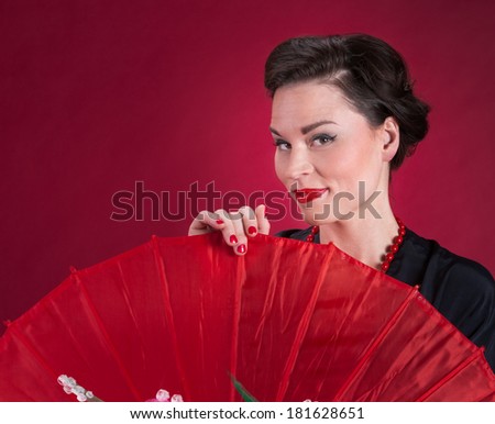 Pinup Girl Looks Over Red Parasol